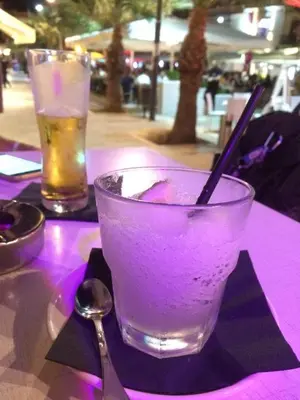a drink in a glass on a table with a spoon at La casetta in Terrasini