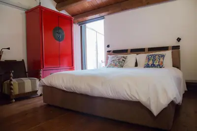 a bedroom with a large bed with a red cabinet at Mau House 44 Apartment in Palermo