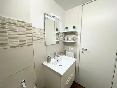 a white bathroom with a sink and a shower at CATHEDRAL APARTMENT in Palermo