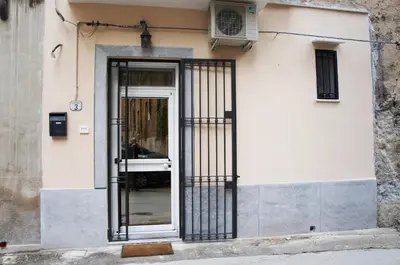 a door to a building with a man sitting in it at CATHEDRAL APARTMENT in Palermo