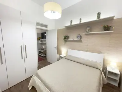 a bedroom with a white bed and a white closet at CATHEDRAL APARTMENT in Palermo