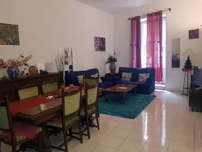 a living room with a blue couch and a table at Casa Rdue a quiet historic center of Palermo in Palermo