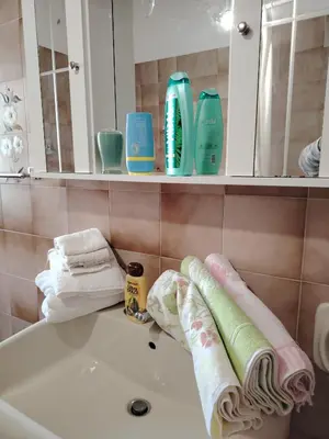 a bathroom with a sink and towels on a tub at Le spezie 2PD Climatizzata in Castellammare del Golfo