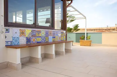 a bench on a building with mosaics on it at Solemar Sicilia - Casa Enza in Santa Flavia