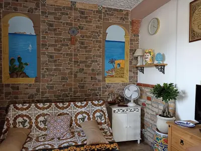 a living room with a couch and a brick wall at Torre Vallelunga in Trabia