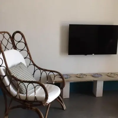 a living room with a chair and a table with a television at Casa Nonnona in Palermo