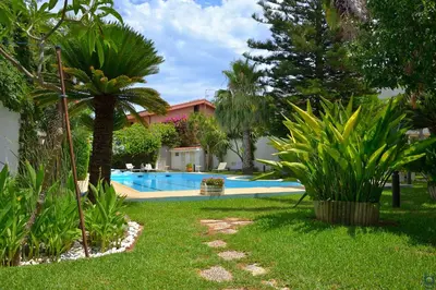 a yard with a swimming pool and palm trees at B&b Mondello Resort in Palermo
