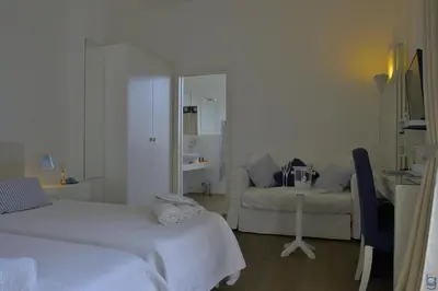a white room with two beds and a couch at B&b Mondello Resort in Palermo