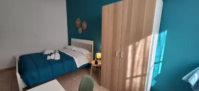 a small bedroom with a bed and a wooden cabinet at Sea Room Aspra in Bagheria