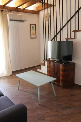 a living room with a tv and a coffee table at Mondello Apartment in Mondello