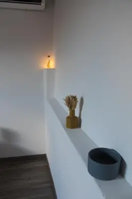 a white room with a black stool and a light at Mondello Apartment in Mondello