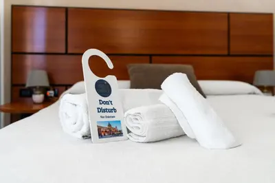 a pile of towels and a sign on a bed at Hotel City Center in Palermo