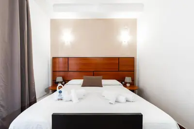 a bedroom with a white bed with a wooden headboard at Hotel City Center in Palermo