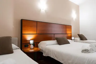 a bedroom with two beds and a wooden headboard at Hotel City Center in Palermo