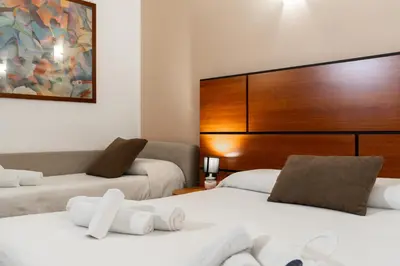 a room with two beds and a large headboard at Hotel City Center in Palermo