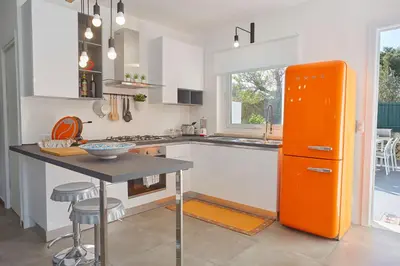 an orange refrigerator in a kitchen with a table at Casa del Melograno con idromassaggio e giardino in Terrasini