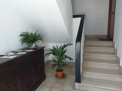 a staircase with potted plants and a wooden dresser at Duchessa in Castellammare del Golfo
