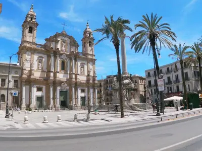 a building with palm trees in front of a street at Gagini House & Terrace in Palermo