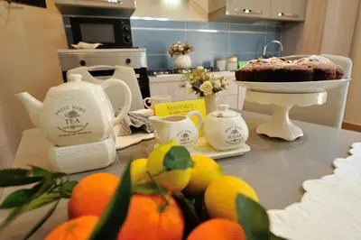 a kitchen counter with a table with a cake and teapots at Terra Sinus Holiday House in Terrasini