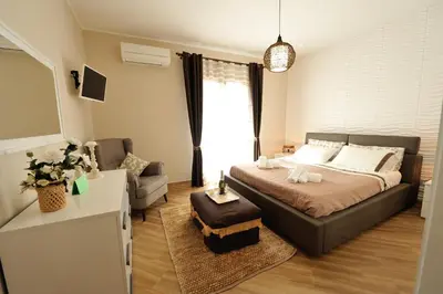 a bedroom with a large bed and a couch at Terra Sinus Holiday House in Terrasini