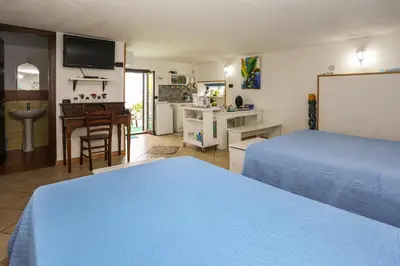 a bedroom with a bed and a kitchen with a table at Benvenuti al Sud in Trabia