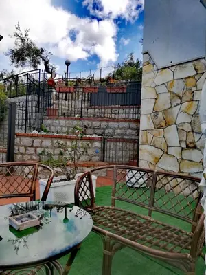 a patio with a table and chairs and a stone wall at Benvenuti al Sud in Trabia