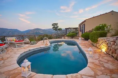 a swimming pool in a yard with a stone wall at Villa Delfino - Scopello-Villas in Scopello