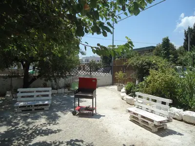 a chair sitting in a yard next to three pallets at casa nina in Mondello