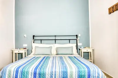 a bedroom with a bed with a blue wall at Annina'S Home Panoramic sea view By Sicily Home Solutions in Castellammare del Golfo