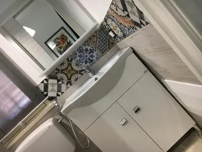 a bathroom with a tub and a mirror and tiles at Finestra Azzurra in San Vito lo Capo