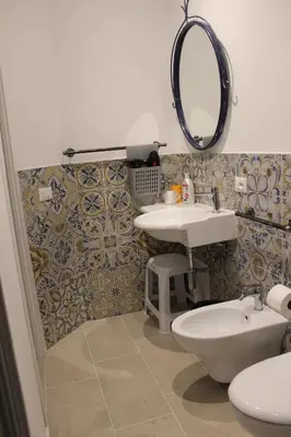 a bathroom with a sink and a toilet and a mirror at cocciu d'amuri in Caccamo