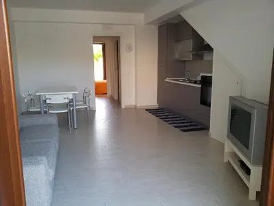 a living room with a couch and a tv and a table at Essenzamare in San Vito lo Capo