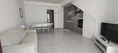a living room with a couch and a kitchen at Essenzamare in San Vito lo Capo