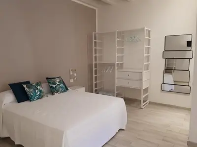 a white bedroom with a white bed and a dresser at Casa di Magda in Castellammare del Golfo