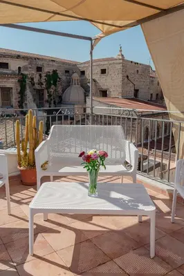 a vase of flowers sitting on a table on a patio at Rooms 19 B&B in Palermo