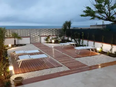 a patio with benches and tables on top of a building at DORIDE Appartamento sulla spiaggia in Balestrate