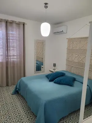 a bedroom with a bed with a blue bedspread at DORIDE Appartamento sulla spiaggia in Balestrate