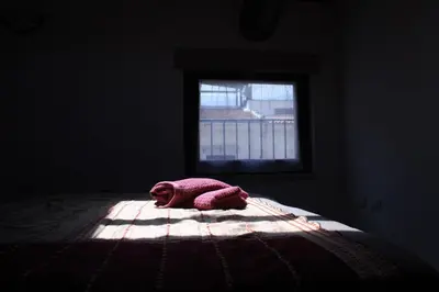 a pink blanket laying on a bed with a window at Casa PAN (Percorso Arabo Normanno) in Palermo