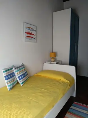 a small bedroom with a bed with a yellow blanket at Casa PAN (Percorso Arabo Normanno) in Palermo