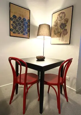 a black table with two red chairs and a lamp at Da Nelly al Politeama in Palermo
