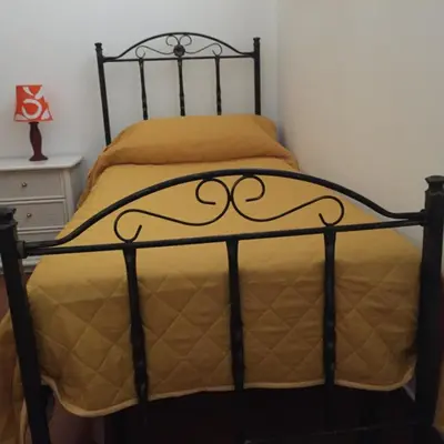 a black bed with a yellow comforter in a bedroom at George House Mondello 32 in Mondello