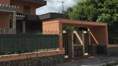 a fence in front of a house with a gate at George House Mondello 34 in Mondello