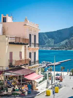 a building with a market in front of the ocean at Casetta Vista Mare in Piazza a Mondello by Wonderful Italy in Palermo