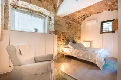 a bedroom with a bed and a chair at Stylish Home in Front of Casa Professa by Wonderful Italy in Palermo