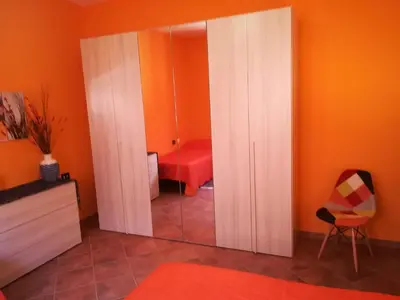 a mirror in a room with a red chair at OrangeBalestrate in Balestrate