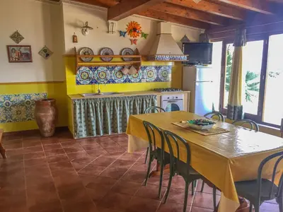 a kitchen with a table and chairs in a room at VILLA VENERE con vista sul mare in San Vito lo Capo