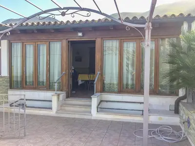 a house with a glass door and a table at VILLA VENERE con vista sul mare in San Vito lo Capo