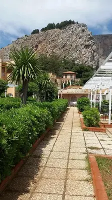 a walk way with a mountain in the background at Casa Vacanze Mondello Mare Piscina ALBAMAOR in Mondello