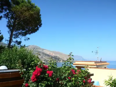 a view of the ocean from a house with flowers at tramonto blu in Palermo