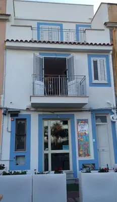 a blue and white house with a balcony at Bed Ponente in Isola delle Femmine